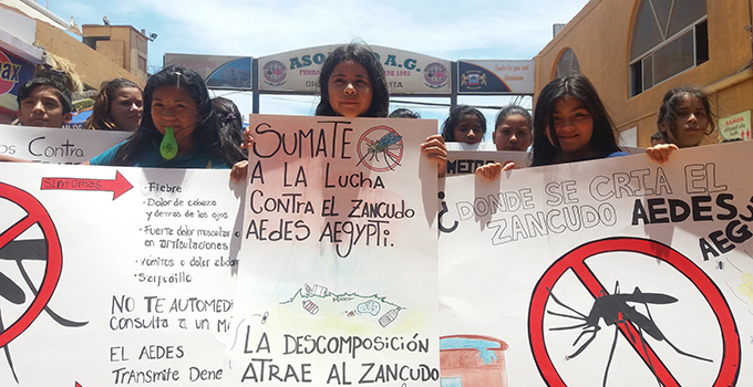 Photo of a group holding signs with information about the zika virus.